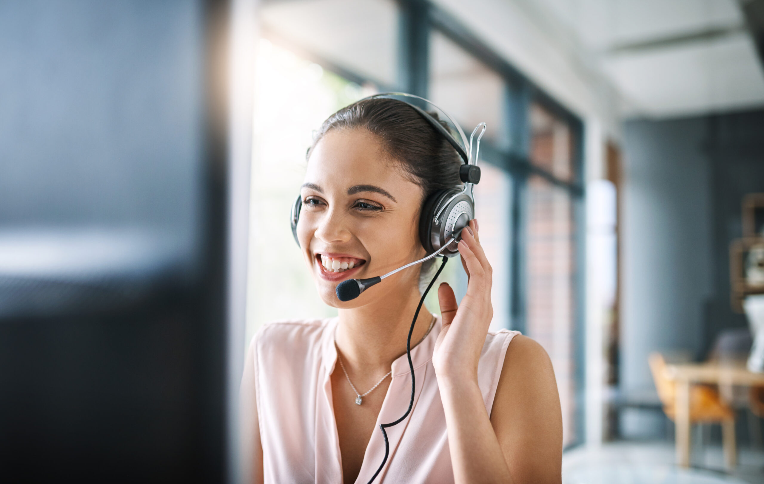 Chica-trabajando-en-call-center-sonriendo-y-atendiendo-clientes-servicio-telemaketing